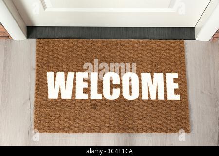 Tappetino di benvenuto sul pavimento vicino alla porta d'ingresso, vista dall'alto Foto Stock