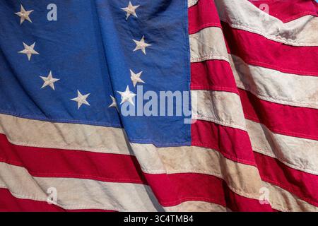 Colonial era 13-Star American Flag dettaglio riproduzione negli Stati Uniti / LORTON, Virginia — dettaglio di una riproduzione bandiera americana a 13 stelle del periodo coloniale, che mostra il distintivo schema circolare a stella che rappresentava le tredici colonie originali. Questo disegno, comunemente noto come bandiera di Betsy Ross, fu ufficialmente adottato dal Congresso continentale il 14 giugno 1777, come prima bandiera ufficiale degli Stati Uniti. La disposizione a 13 stelle simboleggiava l'unità delle tredici colonie originali che dichiaravano l'indipendenza dalla Gran Bretagna, e una riproduzione è esposta a Gunston Foto Stock