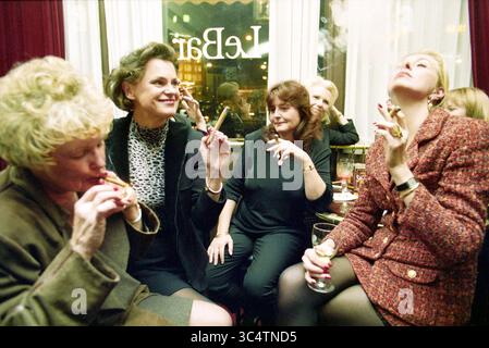 Sigaro fumatori signore, Amsterdam, Amsterdam, Paesi Bassi, 03-11-1997 Whizgle News, Dutch Desk, Paesi Bassi, 1950-2000 Un gruppo di donne si riunisce in un ambiente elegante, impegnato in una conversazione vivace mentre si gustano i sigari. Alcuni indossano un abbigliamento elegante, che trasuda sicurezza e raffinatezza. L'atmosfera è rilassata e sociale, evidenziata da risate e cameratismo. Foto Stock