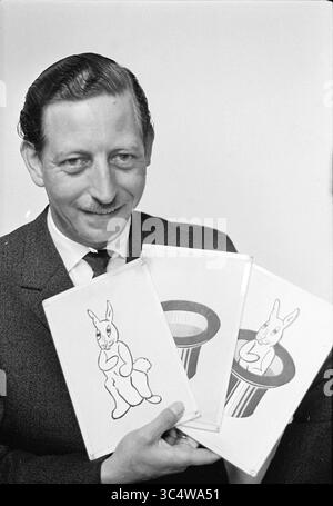 Mago ritratto (uomo) Whizgle News, Dutch Desk, Paesi Bassi, 1950-2000 Un uomo in tuta sorride mentre tiene in mano tre carte illustrate con un coniglio cartoni animati che emerge dal cappello di un mago. Foto Stock