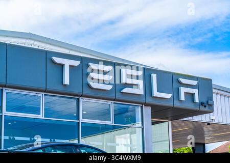 Norwich, Regno Unito – 25 luglio 2025: Segnaletica esterna sul lato di un edificio di concessionaria di Tesla Motor Company Foto Stock