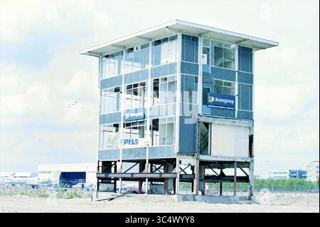 Old Schiphol Tower, Schiphol, Schiphol, 09-06-1999 Whizgle News, Dutch Desk, i Paesi Bassi, 1950-2000 Un edificio parzialmente costruito si erge da solo, con la sua struttura scheletrica e le grandi finestre di vetro, circondato da un paesaggio arido. I segni di un'impresa di costruzioni adornano l'esterno, suggerendo le intenzioni del progetto. Foto Stock