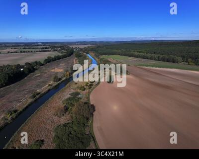 Vista aerea del canale tortuoso che attraversa il paesaggio, contrastando con i campi e la foresta adiacenti, Bralitz, Bad Freienwalde, Brandeburgo, Germania. Foto Stock