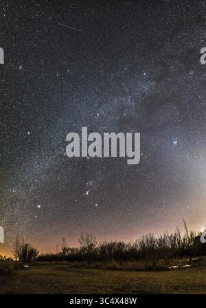 19 marzo 2017 - Canada - Un panorama da orizzonte a Zenith delle consellazioni invernali in una serata di marzo mentre si dirigono verso sud-ovest. Orion è in basso al centro, con la sua cintura rivolta verso il basso verso il Canis Major e verso il Toro. Gemini e Auriga sono in cima, in questo caso vicino allo Zenit in testa. Le stelle luminose, M44, Beehive, (a sinistra) e M45, Pleiadi, (a destra) fiancheggiano la via Lattea. M45 è incorporato nella luce zodiacale. Gli ammassi stellari M35 in Gemini e M41 in Canis maggiore sono visibili anche come punti diffusi, così come diversi altri ammassi stellari. Un paio di piste satellitari sono vi Foto Stock