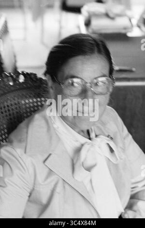 Ritratto Signora Reeser insegnante di musica, musica, ritratti, persone che cantano e musica, 20-09-1979 Whizgle News, Dutch Desk, Paesi Bassi, 1950-2000 Una donna con gli occhiali e un sorriso caldo siede comodamente su una sedia elegante, indossando un abito dai colori chiari impreziosito da un papillon. La sua espressione trasmette un senso di gentilezza e saggezza, riflettendo un momento di facilità e soddisfazione. Foto Stock