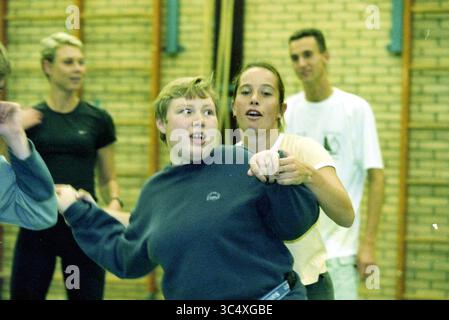 Sport disabili, Hoofddorp, Paesi Bassi, 16-10-2000 Whizgle News, Dutch Desk, i Paesi Bassi, 1950-2000 Un gruppo di persone si impegna in un'attività vivace, con due persone in primo piano che ridono e interagiscono giocosamente. Sullo sfondo, altri osservano o partecipano, creando un'atmosfera energica piena di cameratismo e divertimento. Foto Stock