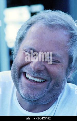 Pagina estiva: Ritratto Oscar Benton, 20-07-1996 Whizgle News, Dutch Desk, Paesi Bassi, 1950-2000 Un uomo con un ampio sorriso e occhi scintillanti irradia gioia, la sua risata contagiosa e calda, mostrando un momento di vera felicità. Foto Stock