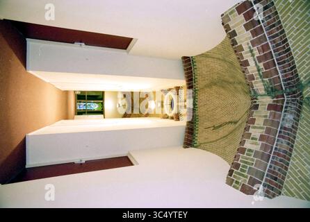 Sacred Heart Church, Apartments, Haarlem, Paesi Bassi, 02-09-1998 Whizgle News, Dutch Desk, Paesi Bassi, 1950-2000 Una prospettiva architettonica unica che presenta una struttura simile a un tunnel con intricati mattoni, che conduce verso una fonte di luce, incorniciata da pareti che mostrano una miscela di superfici lisce e ruvide. Una finestra colorata aggiunge un tocco di vivacità alla scena. Foto Stock
