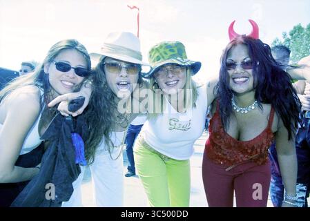 Dance Valley Goers, 03-08-2001 Whizgle News, Dutch Desk, Paesi Bassi, 1950-2000 Un vivace gruppo di quattro persone posa insieme, mostrando un'atmosfera giocosa e vivace. Ogni persona sfoggia scelte di moda uniche, con accessori come cappelli e occhiali da sole, che si aggiungono ai loro stili unici. Sembra che stiano godendo di un momento di divertimento, di gioia e di cameratismo. Foto Stock
