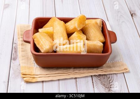 Tradizionale manioca fritta brasiliana in un piatto su un tavolo di legno. Foto Stock