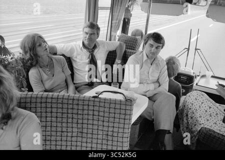 Color Journey Paris, Spectrum, 20-09-1979 Whizgle News, Dutch Desk, Paesi Bassi, 1950-2000 Un gruppo di persone si rilassa su un autobus, seduto comodamente in un'atmosfera intima. Due uomini e una donna si impegnano in una conversazione, mentre un'altra persona sembra essere occupata da qualcos'altro. Gli interni sono decorati con posti a sedere a motivi geometrici e una vista panoramica della strada davanti. Foto Stock