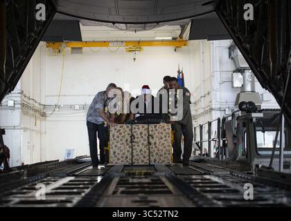 9 dicembre 2019, Agafo Gumas, Guam, Stati Uniti: Ambasciatore degli Stati Uniti negli Stati Federati di Micronesia, Robert Riley, colonnello Matthew Nicholson, vice comandante del 36th Wing, colonnello Otis Jones, comandante del 374th Airlift Wing, e altri fanno la spinta cerimoniale del primo pallet per dare il via all'operazione Christmas Drop presso Andersen Air Force base il 9 dicembre 2019 ad Agafo Gumas, Guam. Negli ultimi 68 anni, l'operazione Christmas Drop dell'aeronautica statunitense ha fornito rifornimenti critici a 56 isole micronesiane, con un impatto di circa 20.000 persone in un'area di 1,8 milioni di miglia nautiche quadrate Foto Stock