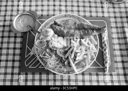 Piatto con pesce fritto, pesca e altri, pescivendoli, pesce, 14-08-1989 Whizgle News, Dutch Desk, Paesi Bassi, 1950-2000 Un pasto a base di pesce fritto croccante accompagnato da patatine fritte dorate, insalata fresca, pomodori a fette e una salsa piccante, il tutto organizzato su un piatto decorativo. Foto Stock