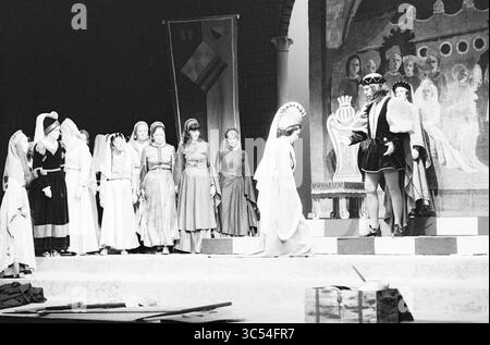 Opera: Il Pirata Bellini, Opera, operetta, 09-11-1977 Whizgle News, Dutch Desk, i Paesi Bassi, 1950-2000 Una scena teatrale con un gruppo di artisti in costumi d'epoca impegnati in uno scambio drammatico, ambientato su uno sfondo dipinto che raffigura un ambiente reale. I personaggi mostrano varie emozioni, contribuendo alla narrazione generale, mentre striscioni e oggetti di scena sono disposti sul palco. Foto Stock
