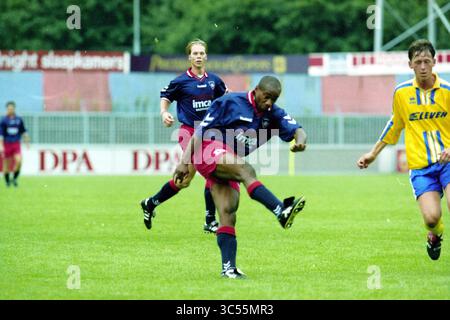Football, Haarlem - Lisse, 16-08-1999 Whizgle News, Dutch Desk, Paesi Bassi, 1950-2000 Un giocatore di calcio colpisce abilmente la palla durante una partita, mentre compagni di squadra e avversari sono impegnati nell'azione sul campo. La scena cattura l'intensità e l'emozione degli sport agonistici. Foto Stock