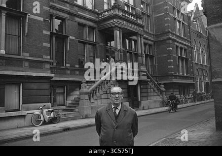 Lord Luyken di fronte al Palazzo di giustizia, persone, 23-11-1964 Whizgle News, Dutch Desk, Paesi Bassi, 1950-2000 Un uomo sta in primo piano, guardando direttamente lo spettatore con un'espressione seria. Dietro di lui, un grande edificio presenta intricati dettagli architettonici e un'ampia scala che conduce all'ingresso. Due persone possono essere viste all'ingresso, mentre le biciclette fiancheggiano la strada, aggiungendo un'atmosfera urbana alla scena. Foto Stock