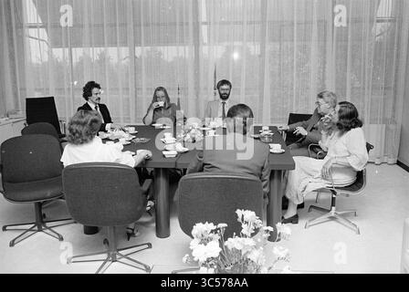 Farewell J. van Rosmalen Spectrum, Spectrum, 28-05-1982 Whizgle News, Dutch Desk, Paesi Bassi, 1950-2000 Un gruppo di otto persone si è impegnato in una conversazione intorno a un tavolo, con tazze da caffè e dolci presenti, circondato da un ambiente luminoso e arioso con grandi finestre e fiori decorativi. Foto Stock