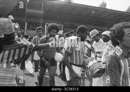 Haarlem - Robin Hood, Football Haarlem, 15-08-1976 Whizgle News, Dutch Desk, Paesi Bassi, 1950-2000 Un gruppo di uomini in un abbigliamento colorato, con motivi vivaci e cappelli, si riuniscono sul campo, con uno che tiene una partita di calcio. Sembrano far parte di un team o di un evento, mostrando un'atmosfera vivace piena di attesa ed entusiasmo. Le tribune circostanti sono piene di spettatori, a indicare un'occasione celebrativa o competitiva. Foto Stock