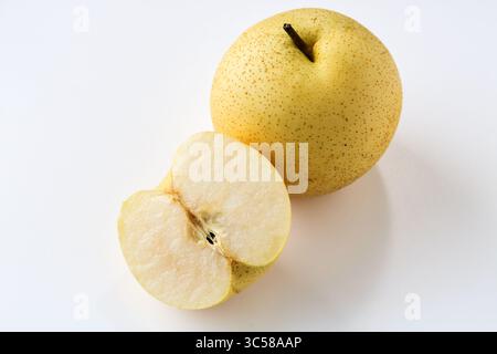 Una pera asiatica fresca, con un frutto intero e un altro tagliato a metà per rivelare la sua polpa e il suo nucleo croccanti, bianchi, isolati su uno sfondo bianco pulito. Foto Stock