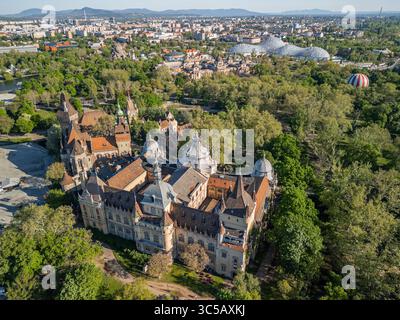 Foto mattutina del drone sul parco cittadino di Budapest che mostra il castello di Vajdahunyad in primo piano, con BalloonFly, bagno termale Széchenyi e il Biodóm Foto Stock