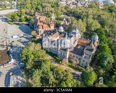 Foto mattutina con drone del castello di Vajdahunyad nel parco della città di Budapest, che mostra l'architettura dettagliata e il fossato da una prospettiva aerea Foto Stock