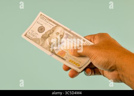 Le banconote da cento dollari sono tenute in mano, pronte per essere consegnate. Foto Stock