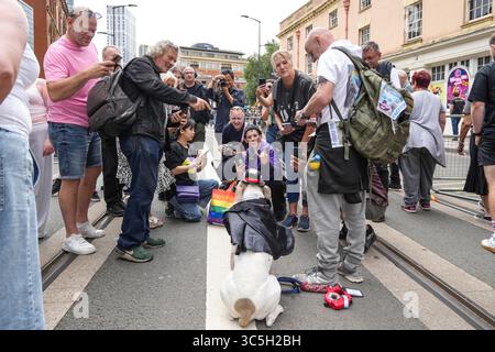 Broad Street, Birmingham, 30 luglio 2025: I fan di Ozzy Osbourne hanno affollato una stella inaspettata del giorno dopo la processione funebre hanno lasciato la città, Bruce il cane è un salvataggio di 5 anni ed è addestrato alla consapevolezza dell'autismo, folle di persone in coda per scattare una foto del compagno Ozzy OsPaw a 4 zampe mentre poggia per le foto. È stato portato a Birmingham dal proprietario Roy Brownlowe, 64, che è anche un fan di Ozzy Osbourne. Crediti: British News and Media/Alamy Live News Foto Stock