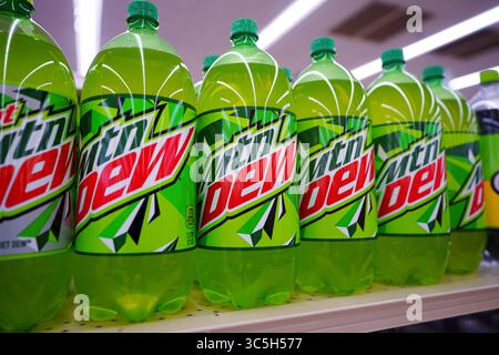 Bottiglie di bibite gassate Mountain Dew di varie dimensioni disposte in modo ordinato sullo scaffale del punto vendita Foto Stock