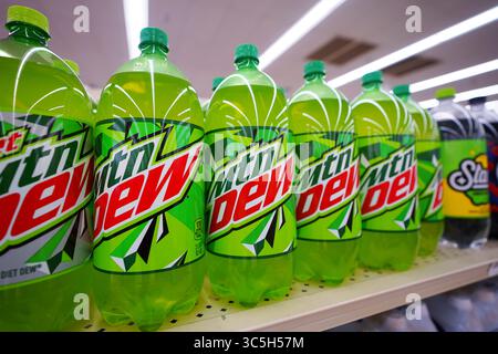 Bottiglie di bibite gassate Mountain Dew di varie dimensioni disposte in modo ordinato sullo scaffale del punto vendita Foto Stock
