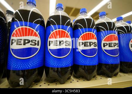 Bottiglie in soda Pepsi in varie misure da litri disposte in modo ordinato sul ripiano del punto vendita Foto Stock