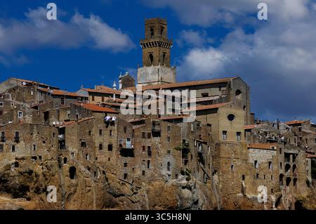 Pitigliano nel sud della Toscana, Italia: Ex torre militare trasformata in campanile o campanile per la Cattedrale dei Santi Pietro e Paolo, con l'aggiunta di stadi superiori. Il campanile ora svetta sopra la citta', costruito sulla sommità piatta di una butte vulcanica di tufo. Negli anni '1500, Pitigliano era conosciuta come "piccola Gerusalemme" per ospitare una comunità di ebrei perseguitati di cui sopravvivono 1598 sinagoga. Foto Stock