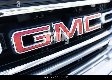 Logo GMC impresso sull'elegante griglia per auto sotto l'illuminazione del salone Foto Stock