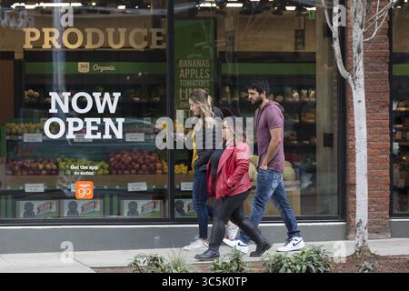 27 febbraio 2020, Seattle, Washington, Stati Uniti: Un gruppo di amici cammina lungo Pike Street di fronte ad Amazon Go Grocery il 27 febbraio 2020. Il primo supermercato tech companyâ€™s ha aperto a inizio settimana nel quartiere Capitol Hill di Seattleâ. I clienti scansionano un'app Amazon Go per entrare nel negozio di 10.000 metri quadrati, prendere i prodotti e andare via senza effettuare il check-out. Amazonâ ™ œJust â Walk Out Technologyâ€ utilizza un complesso sistema di fotocamere e sensori per tenere traccia degli acquisti già in uso nei piccoli minimarket Amazon Go. (Immagine di credito: © Paul Christian Gordon/ZUM Foto Stock
