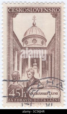 CECOSLOVACCHIA - 1956 marzo 17: 45 haléř francobollo marrone raffigurante la vista di Marianske Lazne (Marienbad). Rilasciato per pubblicizzare le terme cecoslovacche. Mariánské Lázně è una città termale nel distretto di Cheb nella regione di Karlovy Vary della Repubblica Ceca. La maggior parte degli edifici della città proviene dalla sua epoca d'oro nella seconda metà del XIX secolo, quando molte celebrità e i principali governanti europei arrivarono a godersi le sorgenti curative di anidride carbonica. Il centro della città con il paesaggio culturale termale è ben conservato ed è protetto come riserva di monumenti urbani Foto Stock