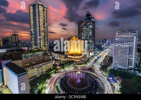 Lo skyline di Giacarta è stato ammirato in una fantastica ora blu, con la grande rotatoria che ospita l'iconico monumento di benvenuto e i grattacieli sullo sfondo Foto Stock