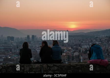 20 marzo 2020 - Sarajevo, Bosnia ed Erzegovina - le giovani donne guardano il tramonto su una collina che domina Sarajevo venerdì 20 marzo. Lo stesso giorno, l'entità della Federazione della Bosnia ha vietato a coloro che hanno più di 65 anni e meno di 18 anni di lasciare le loro case fino al 31 marzo per fermare la diffusione del coronavirus. (Immagine di credito: © Nick St.Oegger/ZUMA Wire/ZUMAPRESS.com) Foto Stock