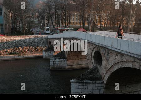 20 marzo 2020 - Sarajevo, Bosnia ed Erzegovina - Una donna cammina attraverso lo storico Ponte Latino di Sarajevo, vicino al luogo dell'assalto dell'arciduca Francesco Ferdinando, che ha portato all'inizio della prima guerra mondiale. Di solito affollato di turisti e locali, il ponte ha visto meno visitatori mentre i residenti osservano il distanziamento sociale e l'autoisolamento per fermare la diffusione del coronavirus. (Immagine di credito: © Nick St.Oegger/ZUMA Wire/ZUMAPRESS.com) Foto Stock