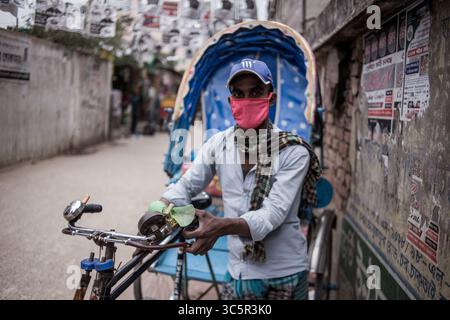 22 marzo 2020: Liton (30) un estrattore di risciò che indossa una maschera facciale. Ha detto che anche se ha paura di Corona, non ha altra scelta di uscire tutti i giorni per lavoro, altrimenti lui e la sua famiglia moriranno di fame.al massimo 4 persone morirono fino al 22 marzo.Chittagong, Bangladesh.22 marzo 2020. (Immagine di credito: © Jashim Salam/ZUMA Wire) Foto Stock