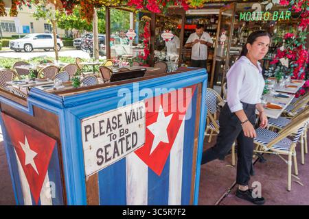 Miami Beach, Florida, South Beach, Washington Avenue, ristorante Esquina Cubana, ingresso, stand hostess con bandiera cubana, si prega di attendere di essere seduti Foto Stock