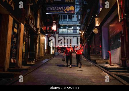 3 aprile 2020, Hong Kong, Cina: La gente cammina su una strada desertica con pub chiusi durante la crisi del coronavirus..bar a Hong Kong, sono stati temporaneamente chiusi perché il governo ordina di chiudere due settimane dalle 18:00 di venerdì 3 aprile per frenare la diffusione del Covid-19. Ogni luogo, esclusivamente o principalmente utilizzato, per la vendita o la fornitura di alcolici, è obbligato a chiudere le porte. (Immagine di credito: © Ivan Abreu/SOPA Images via ZUMA Wire) Foto Stock