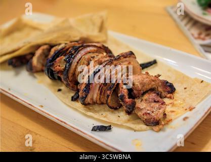 Un piatto di shish kebab di manzo grigliato e cipolle servito su una tradizionale focaccia di lavash in un ristorante turco, un pasto classico a Istanbul, Turchia Foto Stock