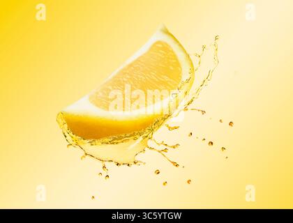Spicchio di limone e spruzzo di bevanda agli agrumi in aria su sfondo giallo gradiente Foto Stock