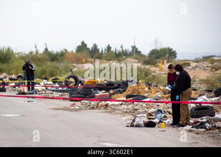 Gli esperti della scena del crimine indagano su un omicidio in Ciudad Juarez piena di detriti. Foto Stock