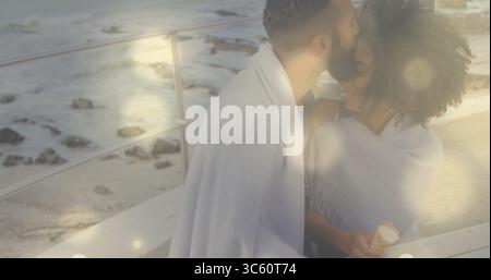 Coppia baciata che tiene il gelato in coperta contro la ringhiera di metallo sul passaggio costiero, copia spazio Foto Stock