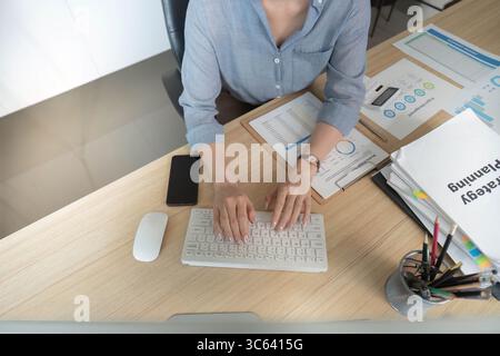 Contabile che scrive i rapporti finanziari sul computer Foto Stock