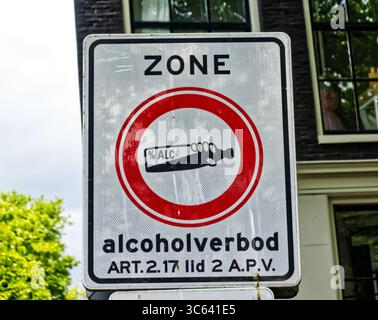Primo piano cartello di divieto di alcol che indica l'area riservata al consumo di alcolici vicino alla strada cittadina di amsterdam, paesi bassi, evidenziando le normative locali Foto Stock