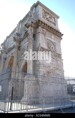 Una vista ravvicinata dell'Arco di Costantino. Gli intricati dettagli del monumento sono visibili dietro una recinzione di metallo scuro in primo piano. Foto Stock