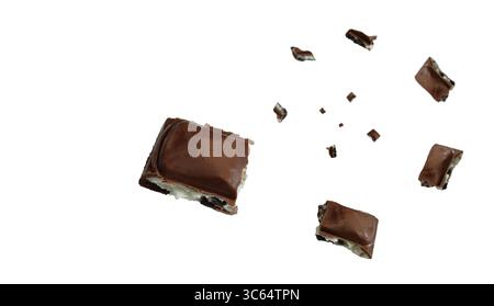 Pezzi di cioccolato fondente esplodono e girano a mezz'aria su uno sfondo bianco pulito. Dinamico e delizioso con spazio per le copie Foto Stock