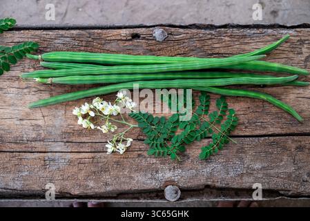 Cialde di bacchette di bacchette di verdure e foglie sane. Moringa Oleifera con foglie su fondo in legno Foto Stock