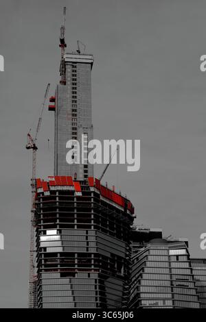 Le crescenti strutture in acciaio e vetro salgono nel cielo come un alto cantiere a Tel Aviv-Jaffa emerge contro un chiaro trambusto urbano dello skyline. Foto Stock